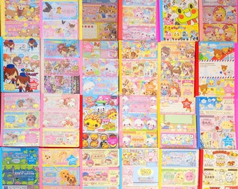 Könnte beinhalten: Eine Sammlung von 36 bunten, illustrierten und gemusterten Papierheften. Die Hefte zeigen verschiedene Designs, darunter Tiere, Blumen und geometrische Muster. Die Hefte sind alle etwa 10 cm breit und 15 cm hoch.