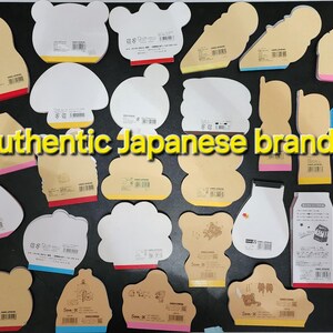 May include: A collection of assorted Japanese stationery featuring various designs and colors. The stationery includes memo pads, notepads, and sticky notes. The text "Authentic Japanese brands" is visible in the center of the image.