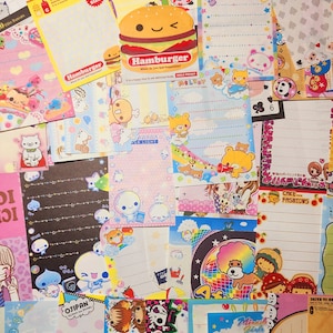 May include: A collection of colorful, patterned paper notes featuring various cartoon characters, including pandas, bears, and a hamburger. The notes are decorated with stars, hearts, and other whimsical designs. The text on the notes includes "Smile Pocket", "Hamburger", "Awaawa Per Light", "Melody", "Minty Pan-ha", "Baby Infinite", "Cake... Fashions", and "Miracle Girls".
