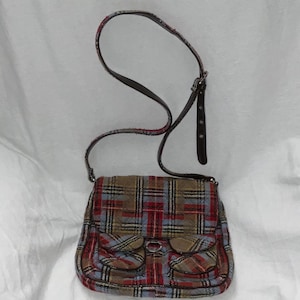 May include: A red, blue, and brown plaid crossbody bag with a brown leather strap and a silver buckle.