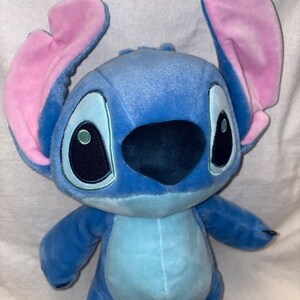 Pu&ograve; includere: Un peluche del personaggio Stitch del film d'animazione Lilo & Stitch. Il giocattolo &egrave; principalmente blu con grandi orecchie foderate di rosa, grandi occhi neri e un naso nero. La pancia &egrave; azzurra.