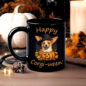 Può includere: Tazza da caffè nera con contorno bianco e il testo "Happy Corgi-ween!" Un cartone animato di corgi con un cappello da strega tiene una zucca di Halloween.