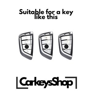Może przedstawiać: Trzy srebrne breloki do kluczyk&oacute;w samochodowych z wieloma przyciskami. Breloki nadają się do kluczyka takiego jak ten. Tekst "CarkeysShop" znajduje się w dolnej części środkowej obrazu.