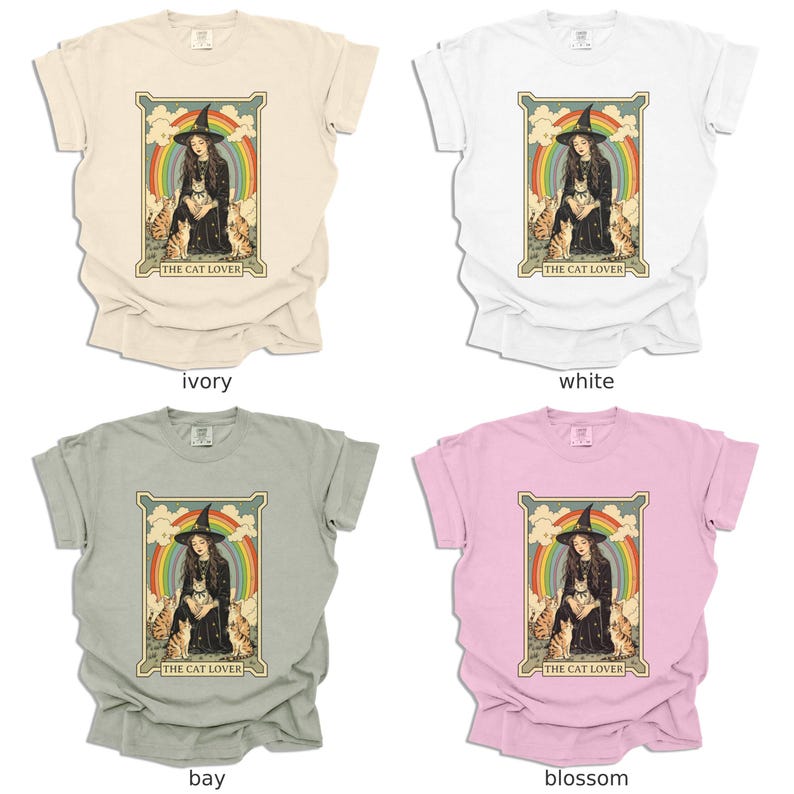 May include: Four t-shirts in different colors: ivory, white, bay, and blossom. Each shirt features a vintage-style illustration of a woman in a witch's hat and robe, surrounded by cats. The text "THE CAT LOVER" is printed below the illustration.