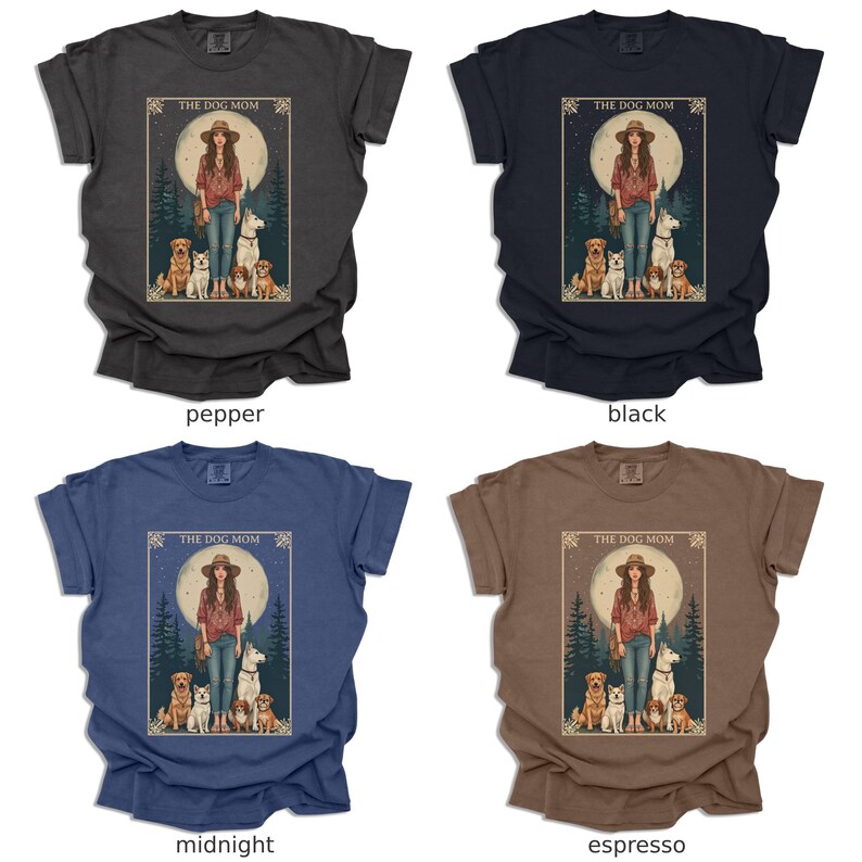 May include: Four t-shirts in different colours featuring a graphic design of a woman with four dogs in front of a full moon. The text "The Dog Mom" is above the image. The colours are pepper, black, midnight, and espresso.