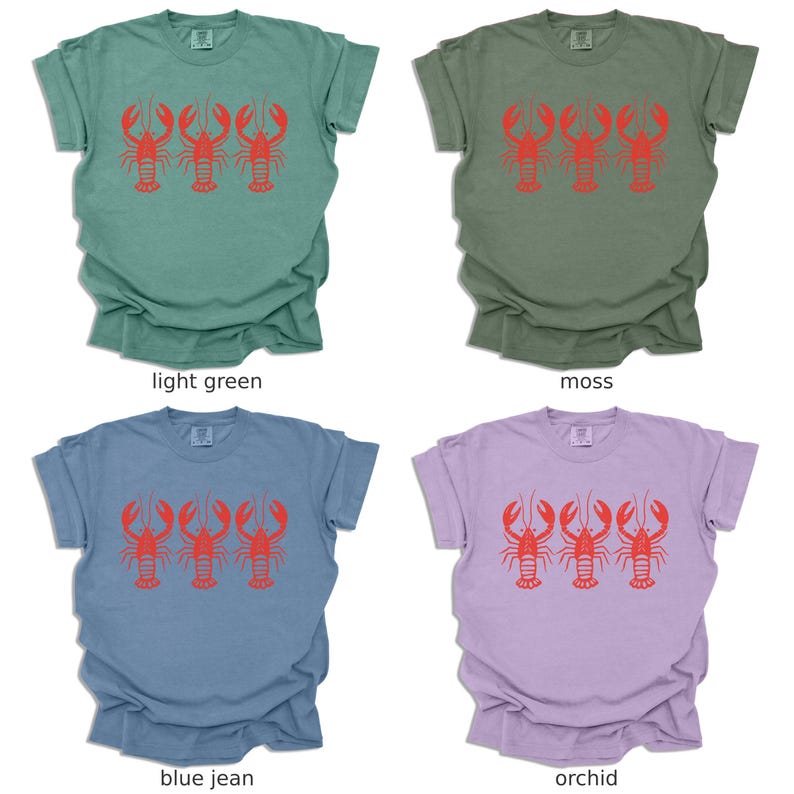 Puede incluir: Cuatro camisetas de diferentes colores: verde claro, musgo, azul vaquero y orqu&iacute;dea. Cada camiseta presenta un gr&aacute;fico de tres langostas rojas.