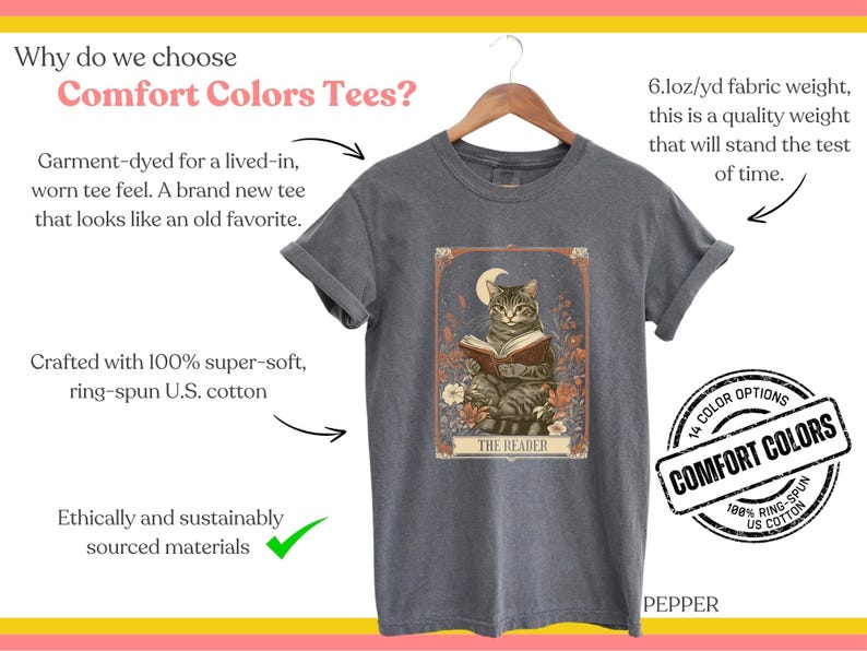 May include: A grey t-shirt featuring a vintage illustration of a cat reading a book. The illustration is surrounded by flowers and has the text "The Reader" at the bottom. The t-shirt is made from 100% ring-spun US cotton and is available in 14 colours.