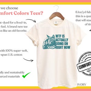 May include: A white t-shirt with a teal cat graphic and the text "WTF IS ACTUALLY GOING ON RIGHT NOW". The shirt is made from 100% ring-spun US cotton and is garment-dyed for a lived-in feel. The shirt is available in 14 colors.