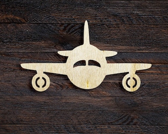 May include: A wooden airplane cutout on a dark brown wood background.