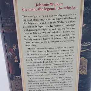 K&ouml;nnte beinhalten: Eine Vintage-Metalldose mit einer Schwarzwei&szlig;illustration von Johnnie Walker, einem Mann in Zylinder und Mantel, der auf eine Pferdekutsche zugeht. Der Text "Johnnie Walker; der Mann, die Legende, der Whisky." ist auf der Dose aufgedruckt.