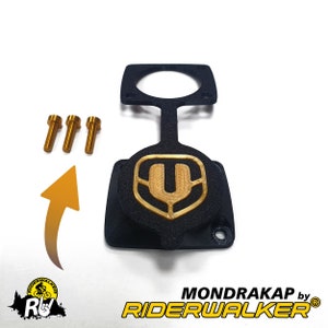 Puede incluir: Cubierta de plástico negro con un logotipo U dorado y tres tornillos dorados. La cubierta está etiquetada "MONDRAKAP by RIDERWALKER".