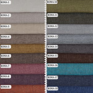 May include: A fabric swatch collection featuring eighteen distinct colour options labelled ROMA-1 through ROMA-18. The textile samples display a consistent woven texture and are arranged in two vertical columns with a zigzag edge down the centre.