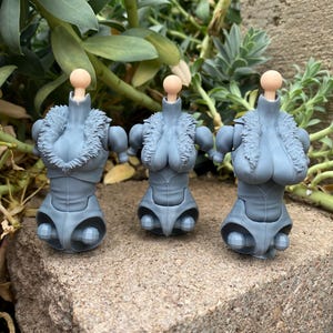May include: Three grey articulated action figure torsos with ball-jointed necks and shoulders. Each torso features a sculpted fur-like collar around the neckline, a defined chest area, and a smooth, segmented midsection with visible hip joints.