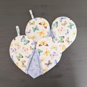 May include: A set of three ceramic mugs with a speckled, matte finish. The mugs are in shades of cream, light gray, and dark gray. Each mug has a simple, modern design and a rounded handle.