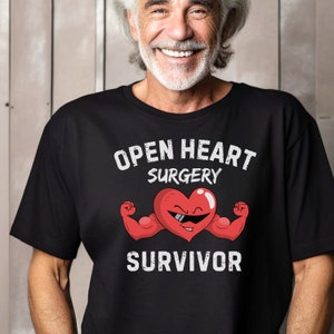 May include: A black t-shirt with the text "Open Heart Surgery Survivor" and a cartoon image of a red heart with sunglasses and flexing its biceps.