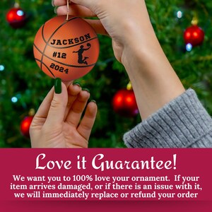 May include: A basketball-themed Christmas ornament with the name "JACKSON", number "12", and the year "2024" printed on it. The ornament is orange and has a basketball design. A silhouette of a basketball player is also on the ornament.