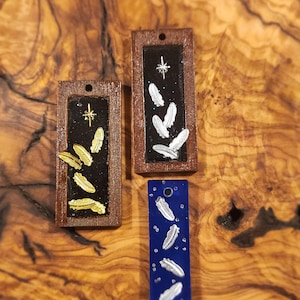 Resin pendants based on Crowley from Good Omens