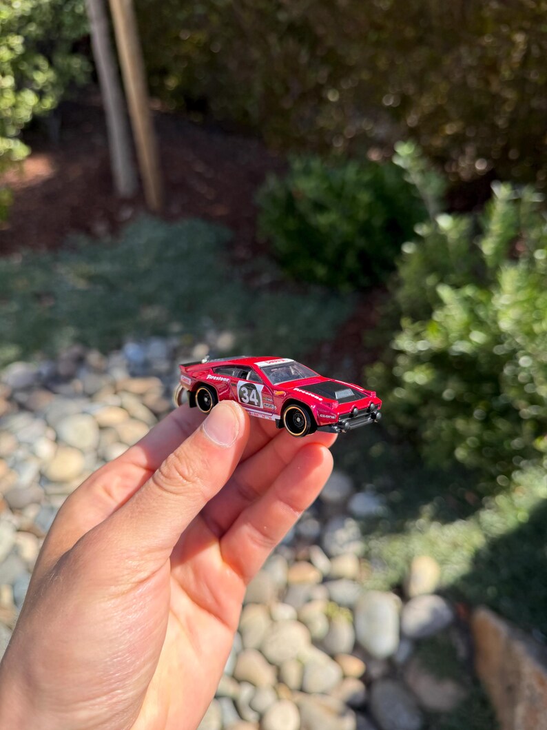 May include: A white ceramic mug with a colorful floral design. The mug features a handle and a wide rim. The flowers are in shades of pink, purple, and yellow. The mug is likely for beverages.