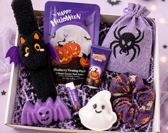 May include: A Halloween gift box containing a black plush bat headband, a purple drawstring bag with a black spider print, a blueberry collagen face mask, a pumpkin hand cream, a blueberry lip balm, a ghost-shaped dish, and a patterned scrunchie.