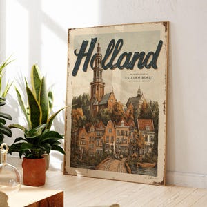 May include: A vintage-style wooden sign featuring the word "Holland" in a blue script. The sign depicts a detailed illustration of a Dutch town with buildings, a church, and a bridge. The sign has a distressed, aged appearance.