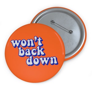 May include: Orange button with the text "won't back down" in white and blue letters.