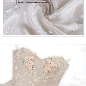 May include: A close-up of a light beige strapless dress with delicate lace detailing and pink flower embellishments. The fabric is a polyester jacquard with a subtle shimmer. The text "This product uses a special fishbone process. Please do not wash it violently in the machine. It is recommended to wash it gently by hand." is visible in the image.