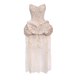 May include: A strapless ivory satin dress with a fitted bodice and a full skirt. The bodice is decorated with delicate floral embroidery and the skirt has layers of ruffles. The dress is accented with a sheer overlay that adds a touch of romance.