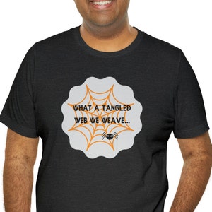 May include: A black t-shirt featuring a white spiderweb graphic and the text "What a tangled web we weave..." in orange.