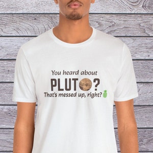 May include: White t-shirt with the text "You heard about PLUTO? That's messed up, right?" and a small image of Pluto with a pineapple emoji.