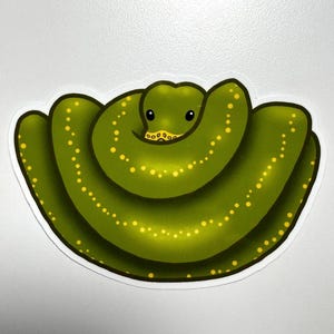 Pode incluir: Adesivo de uma cobra verde com manchas amarelas. A cobra est&aacute; enrolada e tem uma cara sorridente. O adesivo tem uma borda branca e est&aacute; em um fundo branco. Design divertido e l&uacute;dico.