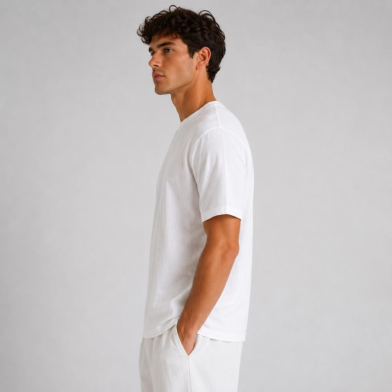 May include: A plain white short-sleeved t-shirt with a crew neckline. The garment is constructed from a solid white fabric and features a standard fit with short sleeves that reach the mid-bicep area, providing a clean and simple appearance.