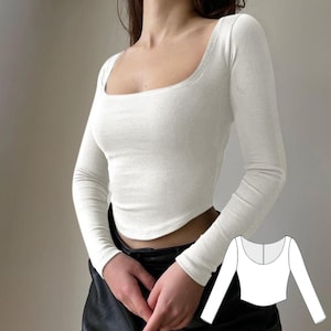 Op de afbeelding: Witte, langarmige crop top met een vierkante halslijn. De top is aangesloten en heeft een licht gebogen zoom. Een lijntekening van de top is te zien in de rechterbenedenhoek van de afbeelding.