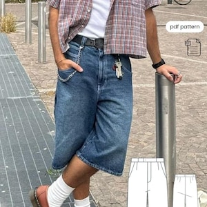 Op de afbeelding: Blauwe denim 90's broek met een relaxte pasvorm. De broek wordt gecombineerd met een geruit overhemd en bruine loafers. De afbeelding bevat ook een PDF-patroon voor de broek.