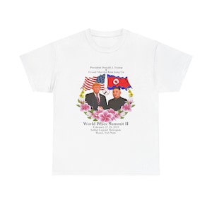 May include: White t-shirt featuring an image of President Donald J. Trump and Grand Marshal Kim Jong Un, with the American and North Korean flags. The text reads "World Peace Summit II" and the date and location.