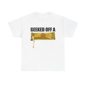 May include: White t-shirt with the text "GEEKED OFF A" above a graphic of a honey stick. The honey stick is gold with a honeycomb pattern and the words "Honey Pack". A drop of honey is dripping from the stick.