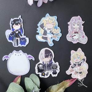 May include: A collection of six anime-style stickers featuring various characters. The stickers showcase a range of designs, including characters with animal ears, and other fantasy elements. The color palette includes shades of blue, pink, and white.
