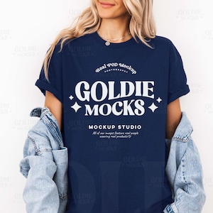 May include: A navy blue t-shirt with white text that reads "Real POD Mockup Photography Goldie Mocks Mockup Studio All of our images feature real people wearing real products."