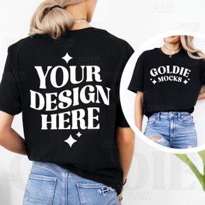 Puede incluir: Una maqueta de camiseta negra con el texto "YOUR DESIGN HERE" en blanco en la parte posterior. La camiseta la lleva puesta una persona con el pelo rubio y va combinada con unos vaqueros azules.