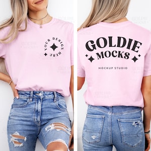 Puede incluir: Una camiseta rosa con un diseño negro en la parte delantera que dice "Your Design Here" con una estrella y un diseño negro en la parte trasera que dice "Goldie Mocks Mockup Studio" con estrellas.