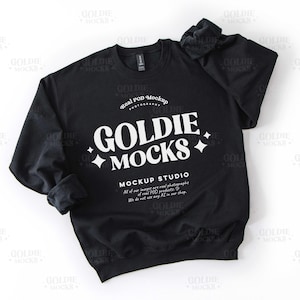 Pode incluir: Camisola de gola redonda preta com o texto "Goldie +Mocks" e "Mockup Studio" em branco. O texto "Real POD Mockup Photography" também está em branco.