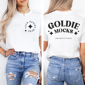 May include: White t-shirt mockup with a black star design on the front and the text "Goldie Mocks Mockup Studio" on the back. The model is wearing blue jeans with distressed details.