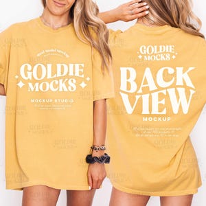Puede incluir: Camiseta de color amarillo mostaza con el texto "GOLDIE MOCKS" en la parte delantera y "BACK VIEW MOCKUP" en la trasera. La camiseta es una maqueta para un estudio de diseño.