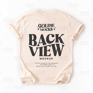 以下が含まれることがあります： ベージュのTシャツのモックアップで、背面に「GOLDIE MOCKS」と「BACK VIEW MOCKUP」のテキストが印刷されています。当社の画像はすべて、実際のPOD製品の実際の写真です。当社のショップでは、AIは使用していません。