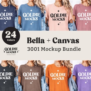 Puede incluir: Un paquete de maquetas de 24 camisetas Bella + Canvas 3001 en varios colores. Las camisetas presentan un dise&ntilde;o gr&aacute;fico blanco con el texto "GOLDIE MOCKS".