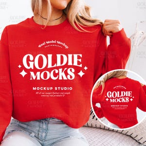 May include: Red crewneck sweatshirt with the text "Goldie Mocks" in white, featuring a diamond pattern and the words "Mockup Studio" and "All of our images feature real people wearing real products".