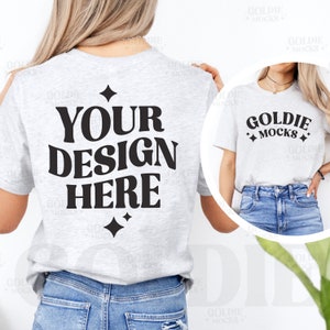 May include: A gray t-shirt with the text "YOUR DESIGN HERE" in black retro-style font. The shirt is being modeled by a person wearing blue jeans.