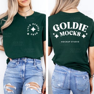 May include: A dark green t-shirt with white text that reads "Goldie Mocks" and "Mockup Studio" on the back. The front of the shirt has a white circle with a star and the text "Your Design Here".