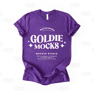 Puede incluir: Maqueta de camiseta morada con el texto "Goldie Mocks" y "Mockup Studio" en blanco. El texto "Real POD Mockup Photography" también es visible en blanco.