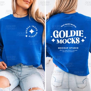 May include: A royal blue sweatshirt with a white logo that says "Goldie Mocks" on the back and "Gildan 18500" on the front. The sweatshirt is being modeled by a person wearing blue jeans.