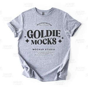 May include: A heather gray t-shirt mockup with the text "Goldie Mocks" and "Real POD Mockup Photography" in black. The text "Mockup Studio" is also in black and says "All of our images are real photographs of real POD products. We do not use any AI in our shop."